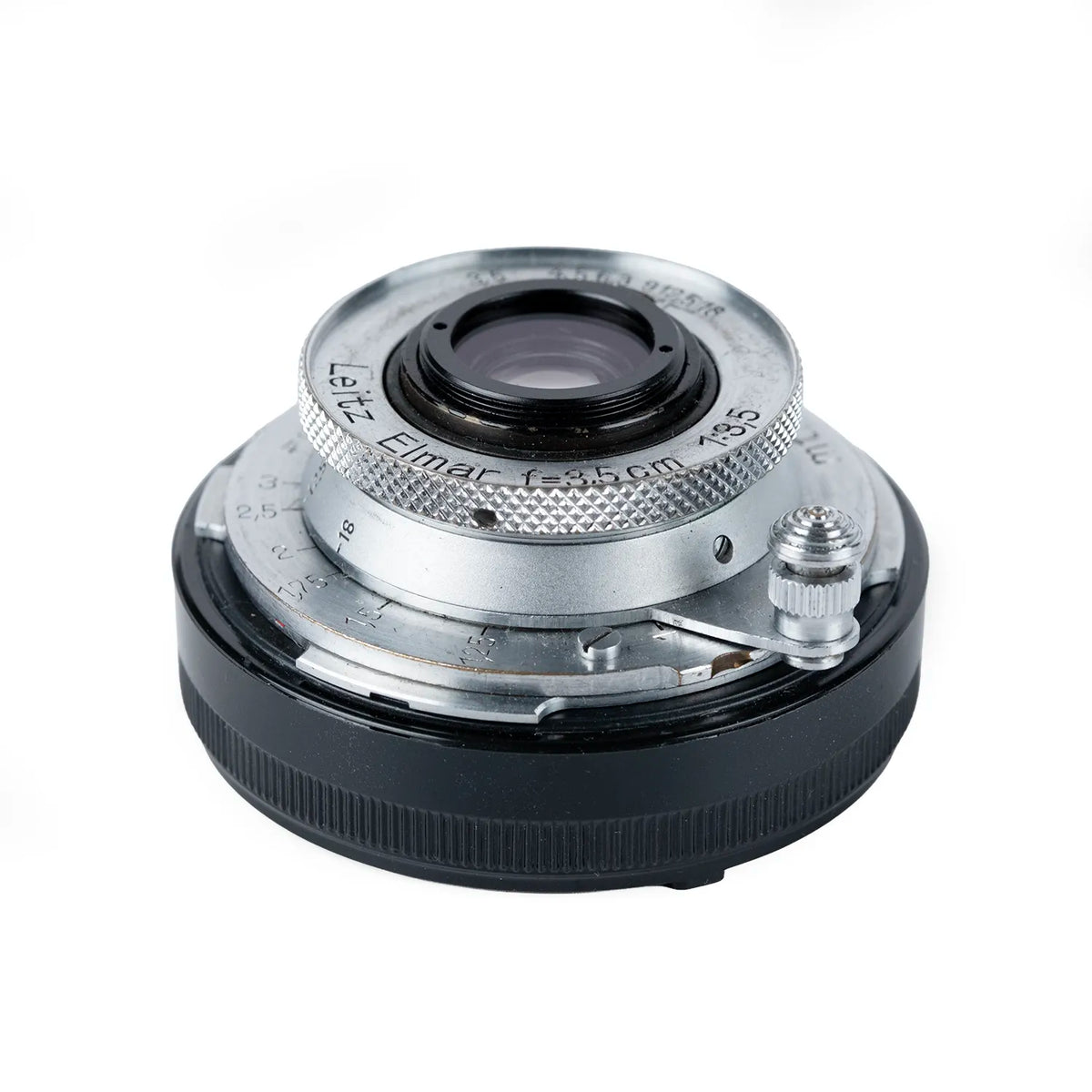 A vintage LEica Elmar 35mm f/3.5 camera lens adapter with a silver-toned metal front ring and a black ribbed rear mount, shown on a white background.